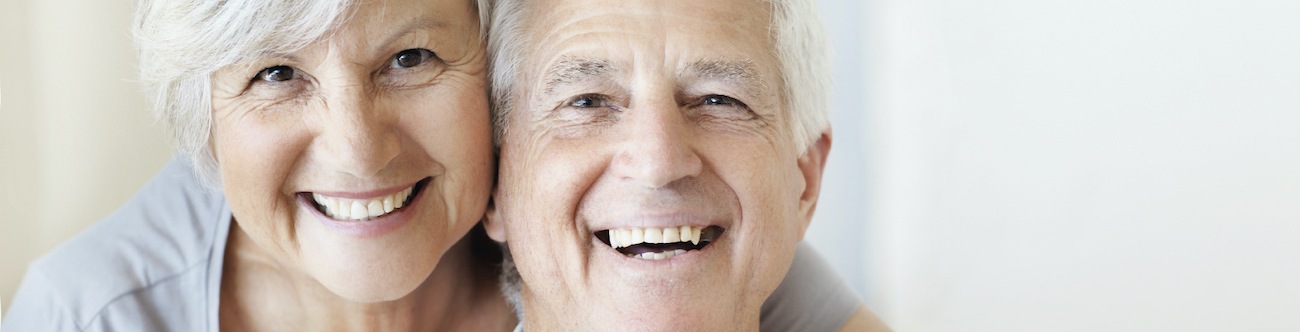 Older couple smiling and posing in a bright room